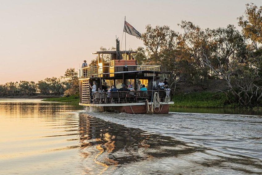 A riverboat with passengers, surrounded by trees and water. 4