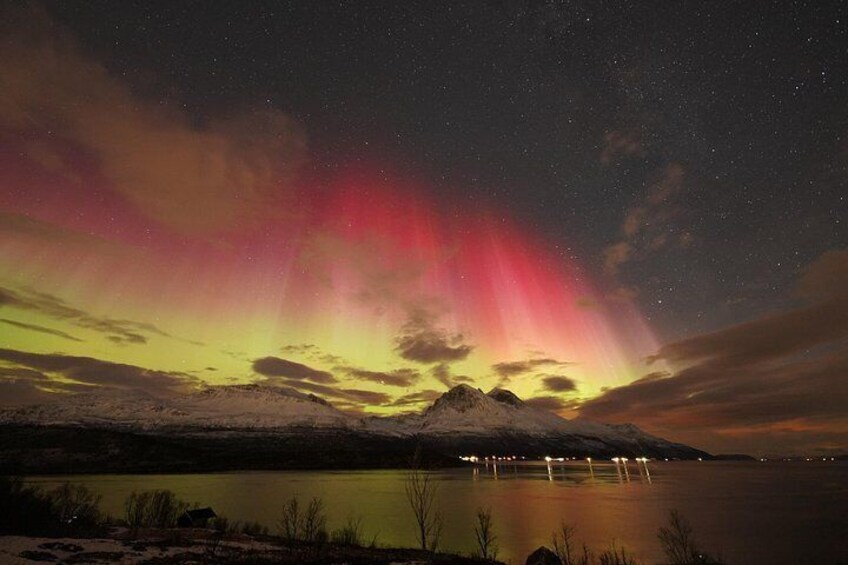 A night sky with the aurora borealis over a snowy landscape and a calm lake. 1