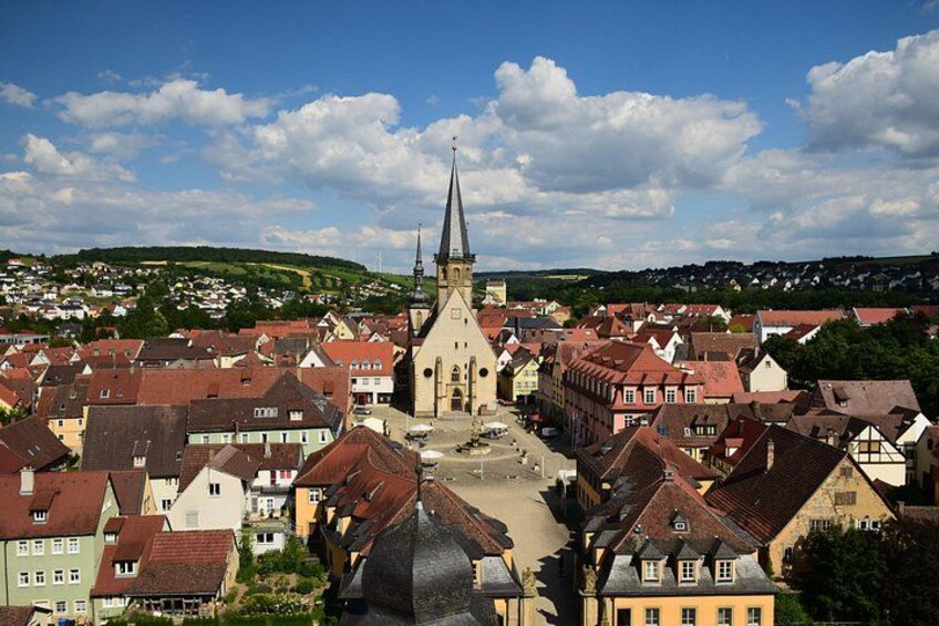 En by med en markant kirke, røde tage og en klar blå himmel. 2