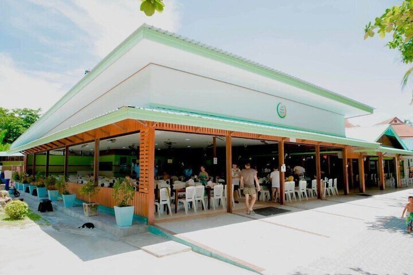 An outdoor cafe with a covered seating area and potted plants. 4