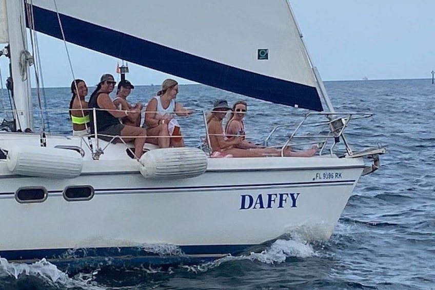 Een zeilboot genaamd DAFFY op het water, met mensen aan boord. 4