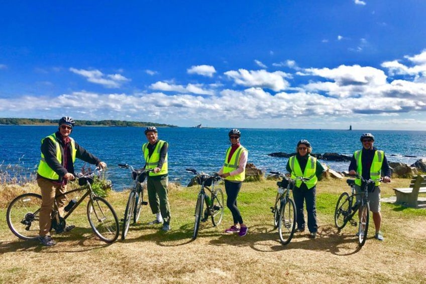 A group of cyclists by a lake with clear skies. 3