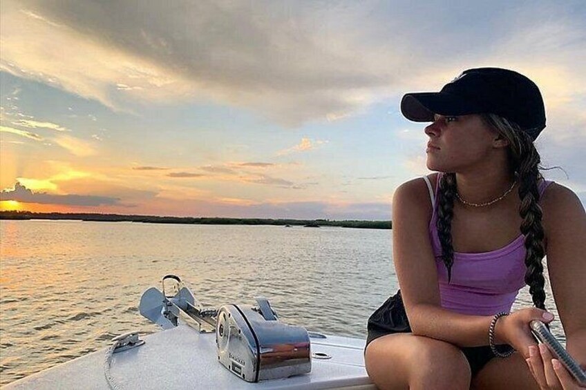 A person on a boat with a sunset in the background. 4