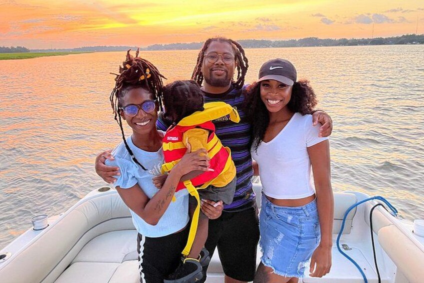A family on a boat with a sunset in the background. 3
