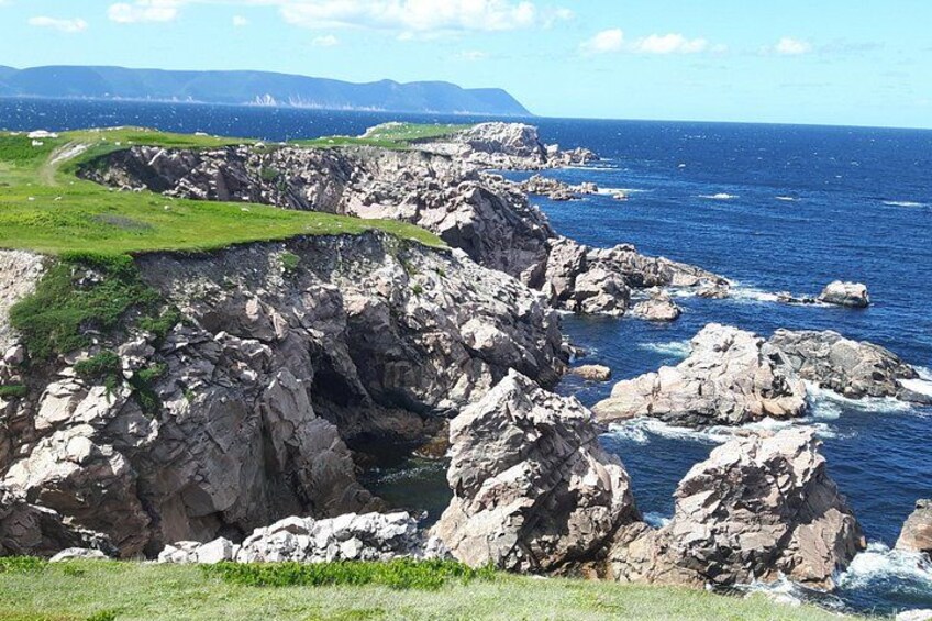 A rugged coastline with rocky cliffs and a clear blue sea. 3
