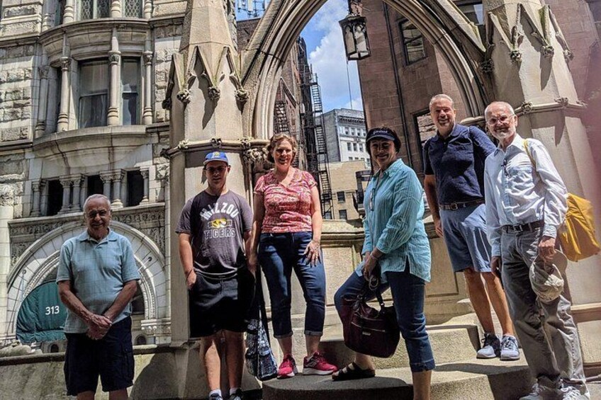 A group of people standing in front of a historic building with Gothic architecture. 2