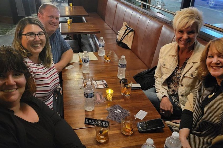 Un groupe de personnes est assis à une table en bois dans un restaurant, et un panneau indique « RÉSERVÉ ». 2