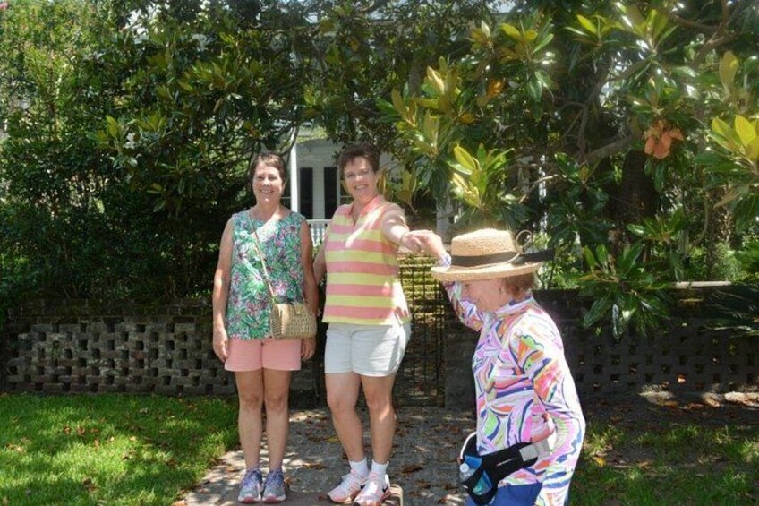 Tres personas de pie al aire libre, una con sombrero, otra con camisa a rayas y la tercera con blusa estampada. 1