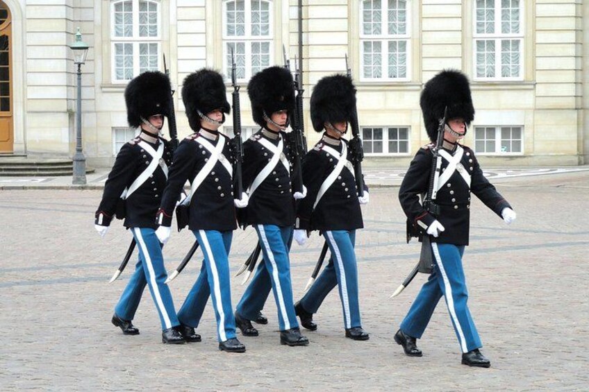 Een groep bewaarders in uniform loopt in een formatie. 4