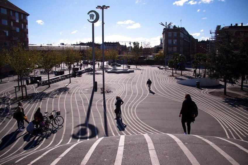 Un passage piéton où l’on voit des personnes qui marchent, des vélos garés et des bâtiments en arrière-plan. 3