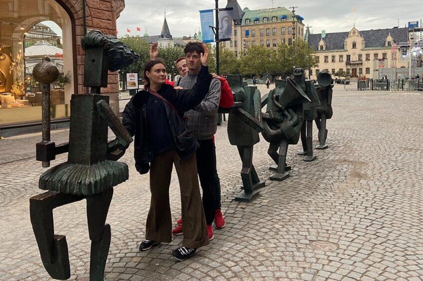 Een stel staat voor een sculptuurinstallatie op een stadsplein. 2