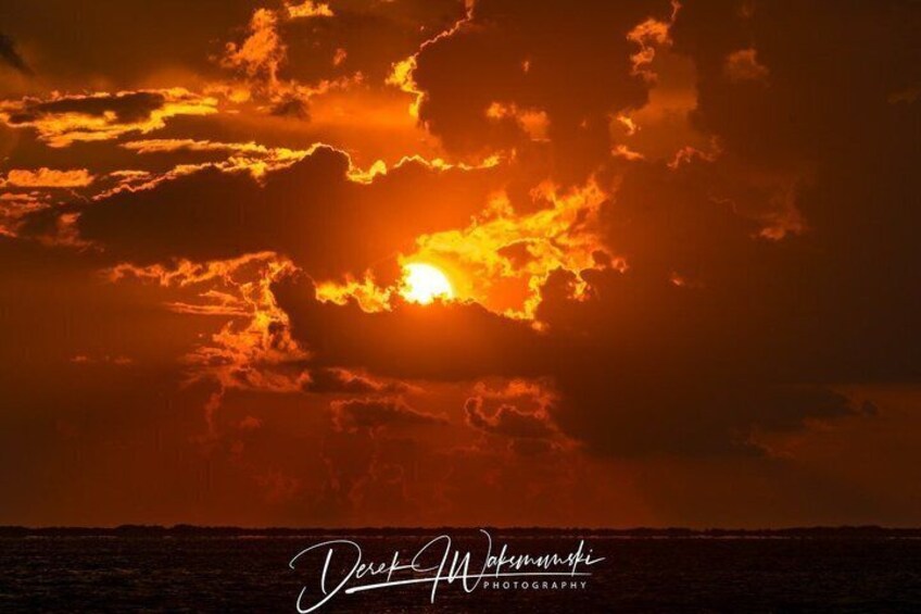 A sunset over the ocean with clouds. 5