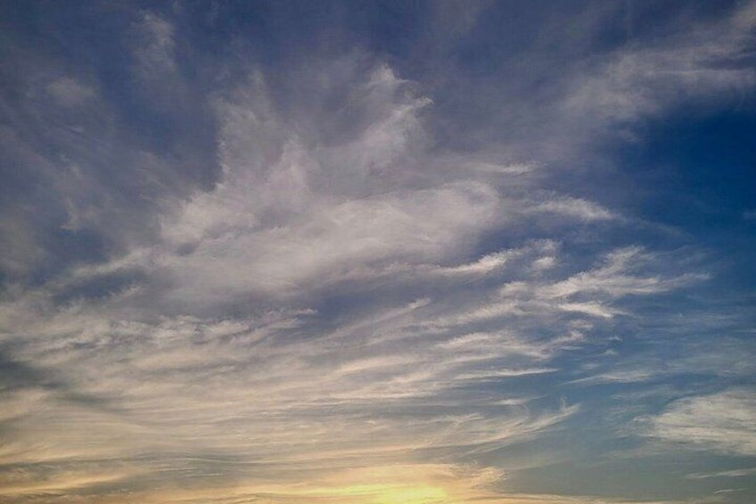 A sky with scattered clouds and a hint of sunlight near the horizon. 3
