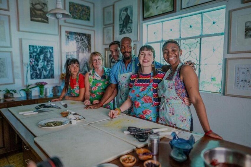 Un gruppo di persone in cucina, con materiali per arte e un'ampia finestra. 1