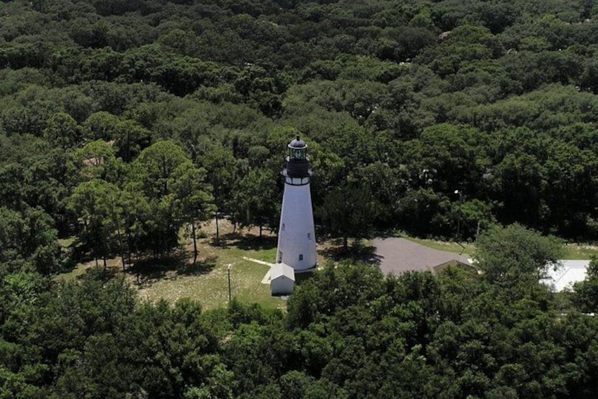 A lighthouse surrounded by dense forest. 2