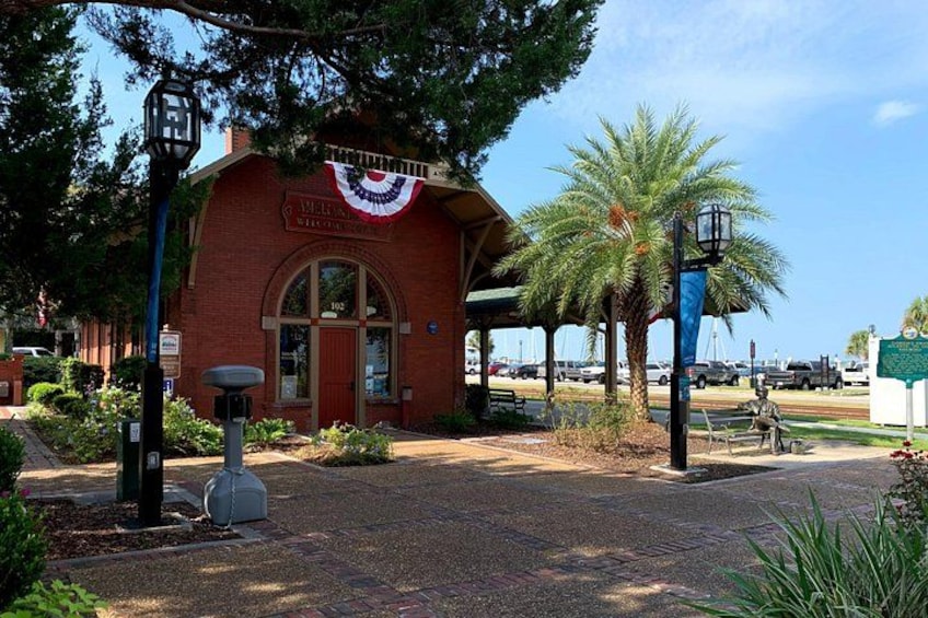 A red brick building with a sign, a street lamp, and a palm tree. 5