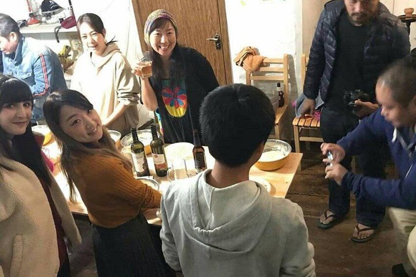 Un grupo de personas alrededor de una mesa con botellas y vasos, lo que sugiere una reunión social. 2