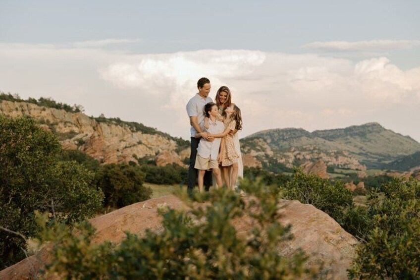 A couple embracing on a rocky outcrop with a mountainous landscape in the background. 5