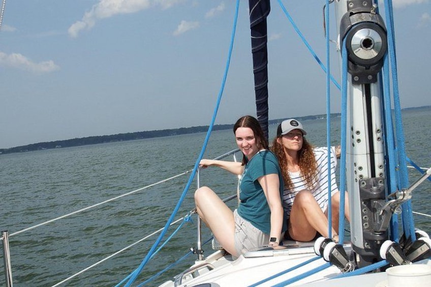 Twee personen op een zeilboot, met een heldere lucht en rustig water. 4