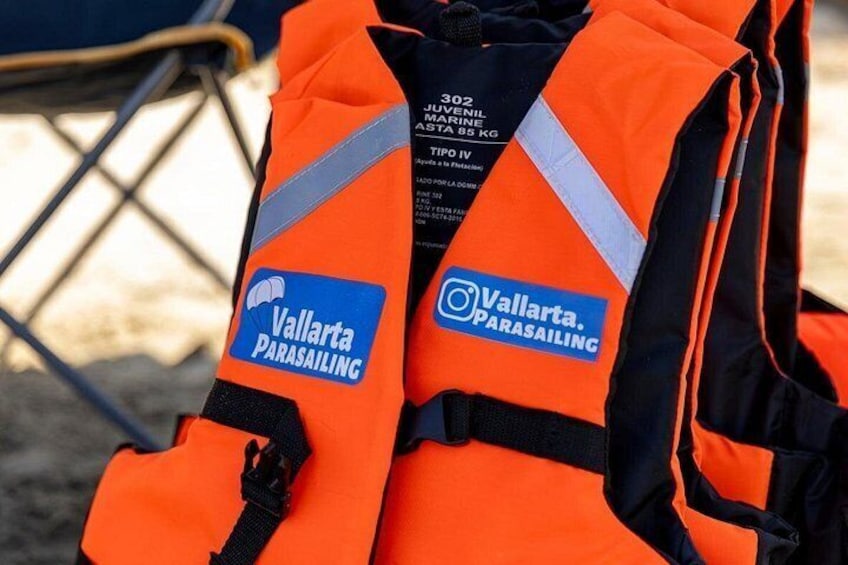 An orange life jacket with the Vallarta Parasailing logo. 4