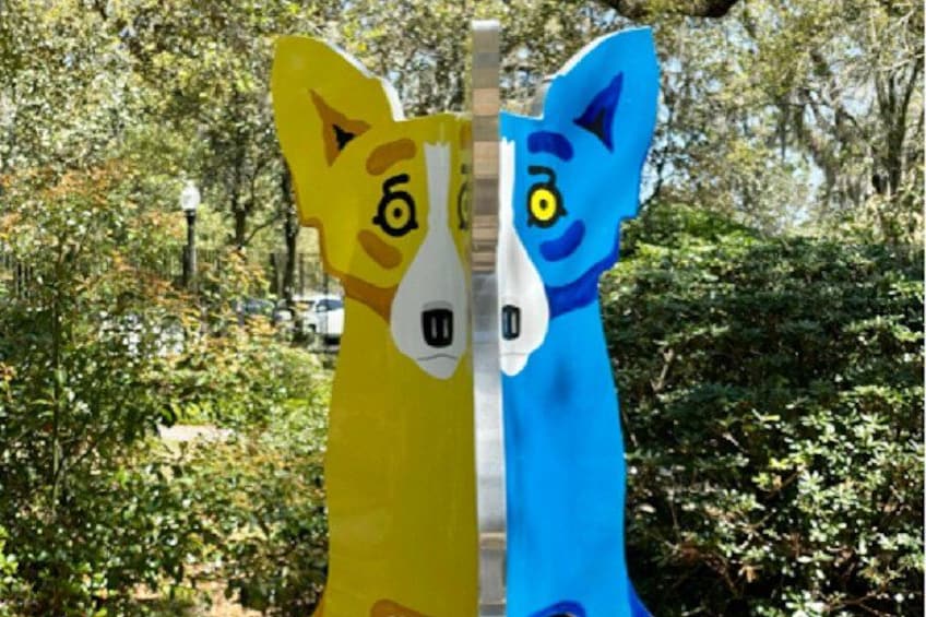 Two colorful animal sculptures, one yellow and one blue, in a park with trees and a street lamp in the background. 3