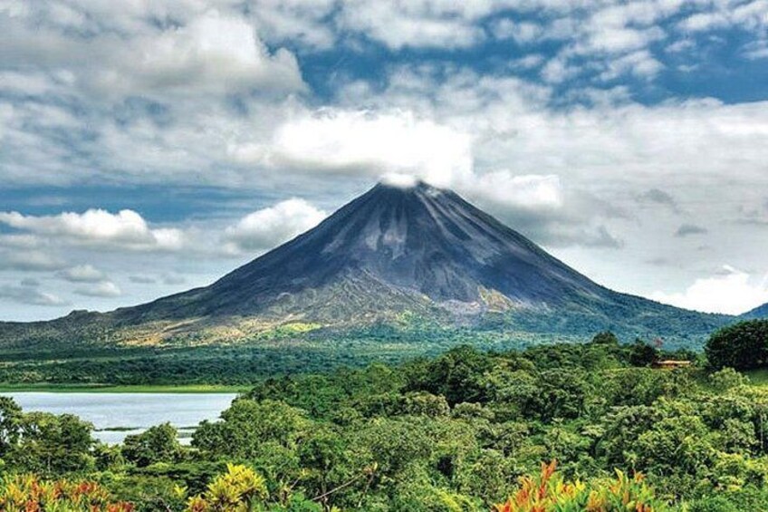 A mountain with a lake in the foreground and a cloudy sky. 3
