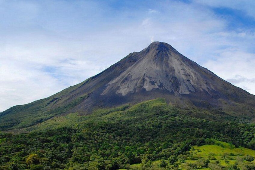 A mountain with a conical shape, surrounded by lush green vegetation. 2