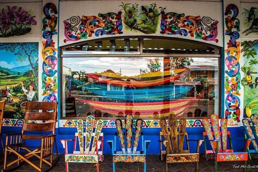 Un interno colorato con un'ampia finestra, sedie blu e elementi decorativi. 2