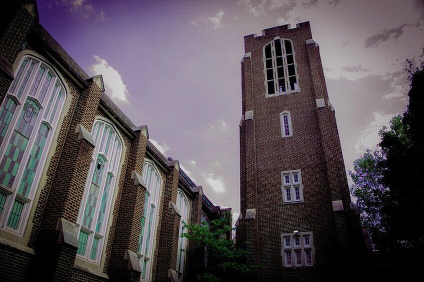 Una iglesia con una torre alta y ventanas de arco. 2