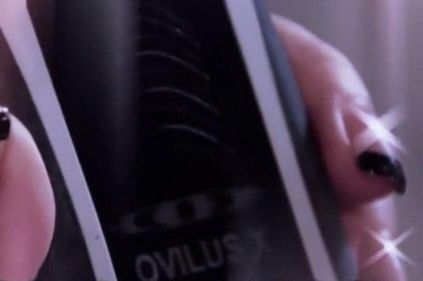 Een persoon houdt een zwart object vast met de tekst 'OVILUS'. 5
