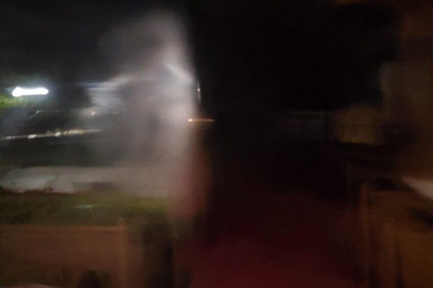 A blurred outdoor scene with a red pathway and indistinct lights in the background. 3