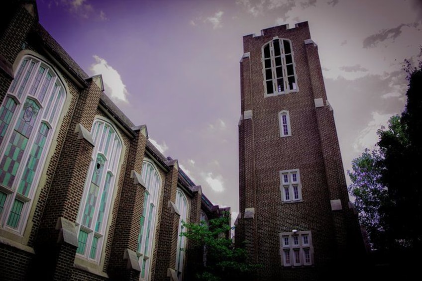 Een gebouw van baksteen met bogen en een hoge toren. 2