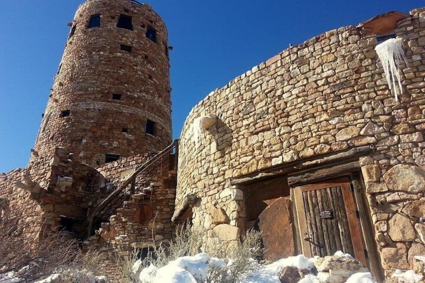Ein Steinturm und ein Gebäude mit einer Holztür. 2