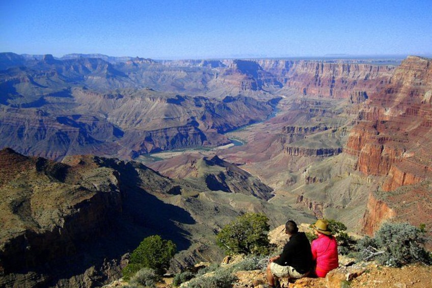 A canyon landscape with layered rock formations and a river. 2