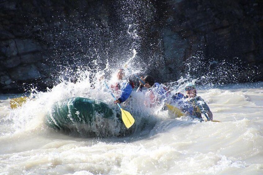 A group of people kayaking in a river with white water rapids. 3