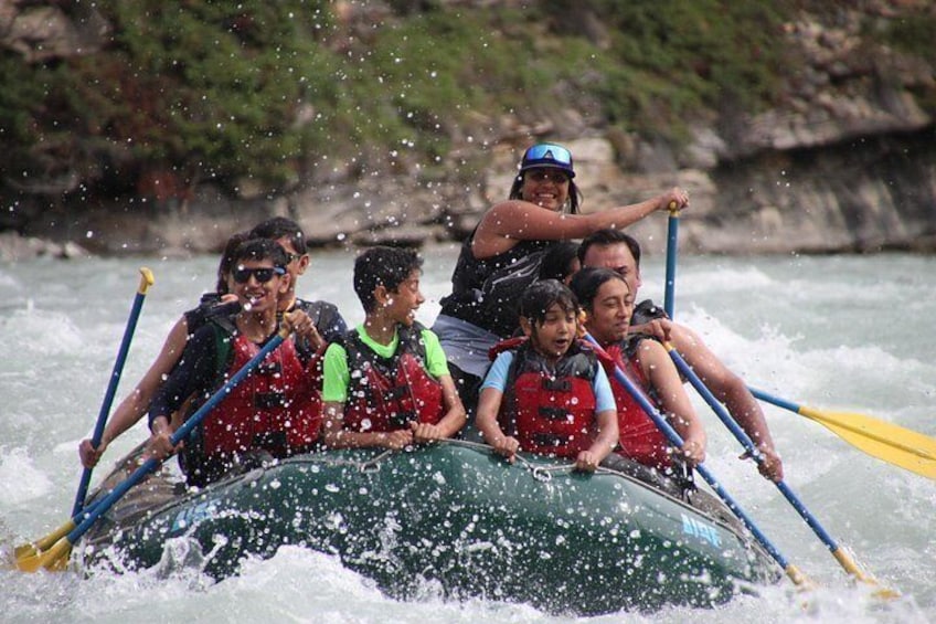 A group of people in a raft navigating a river. 4