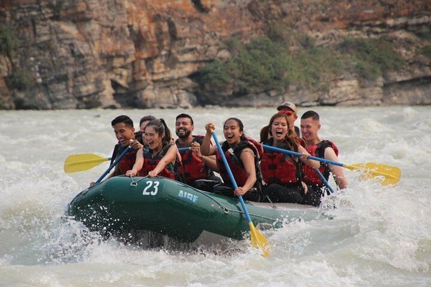 A group of people in a raft navigating a river. 2