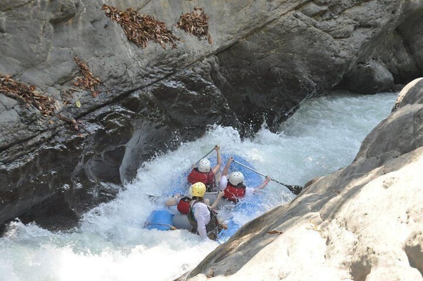 Een groep mensen die op een raft een rivier afdaalt. 4