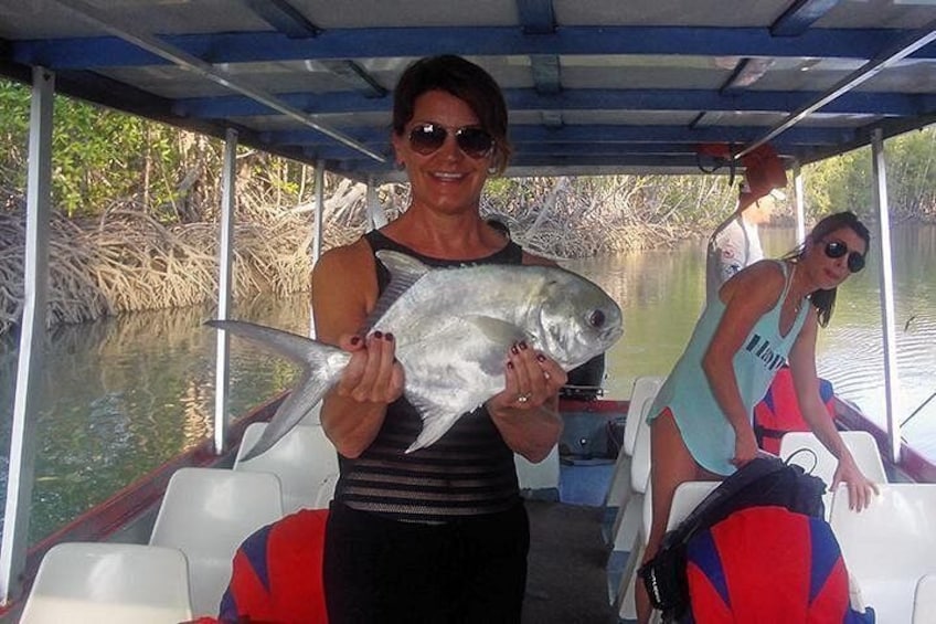 A person holding a fish on a boat. 1