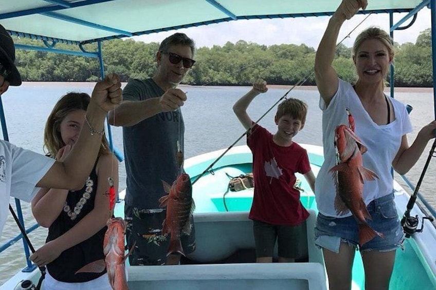 A group of people on a boat holding fish. 4