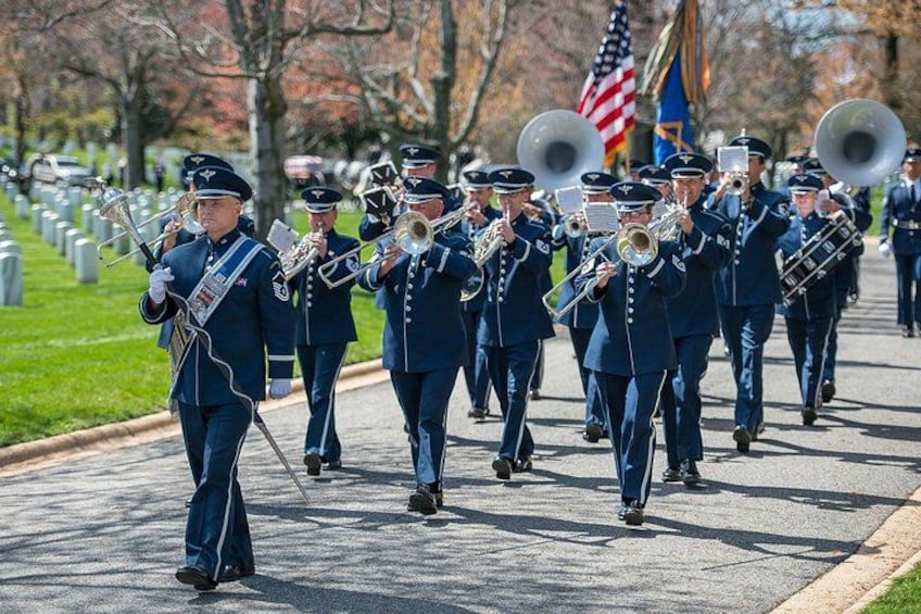 A marching band in uniform on a street. 1