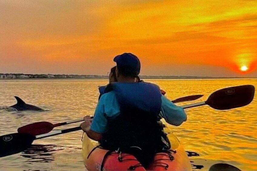 Una persona remando en kayak sobre un cuerpo de agua durante el atardecer. 1