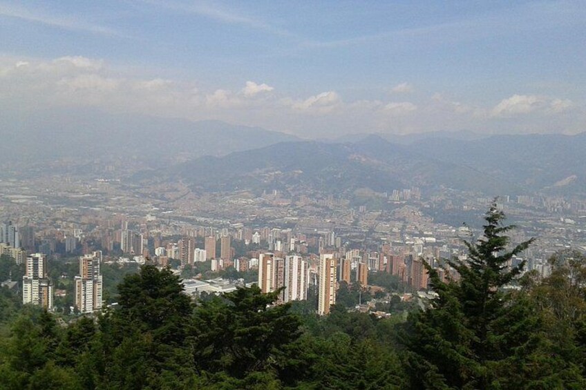 A cityscape with high-rise buildings, a dense urban area, and a mountainous backdrop. 1