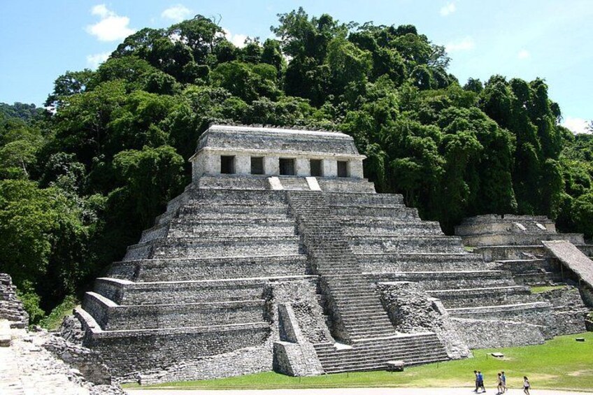 En stor pyramidekonstruktion med flere niveauer, omgivet af frodig, grøn skov. 4