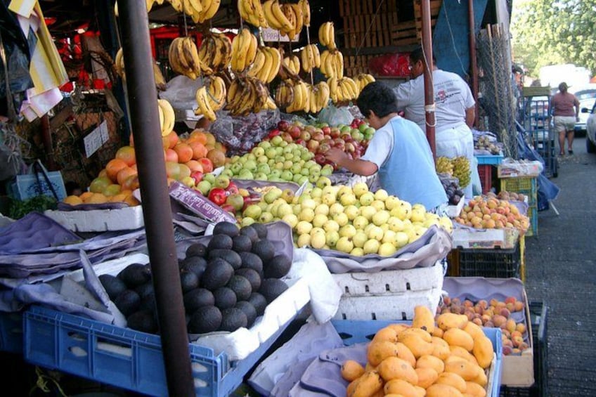 En fruktmarknad med ett varierat utbud av frukter, som bananer, äpplen och apelsiner. 4