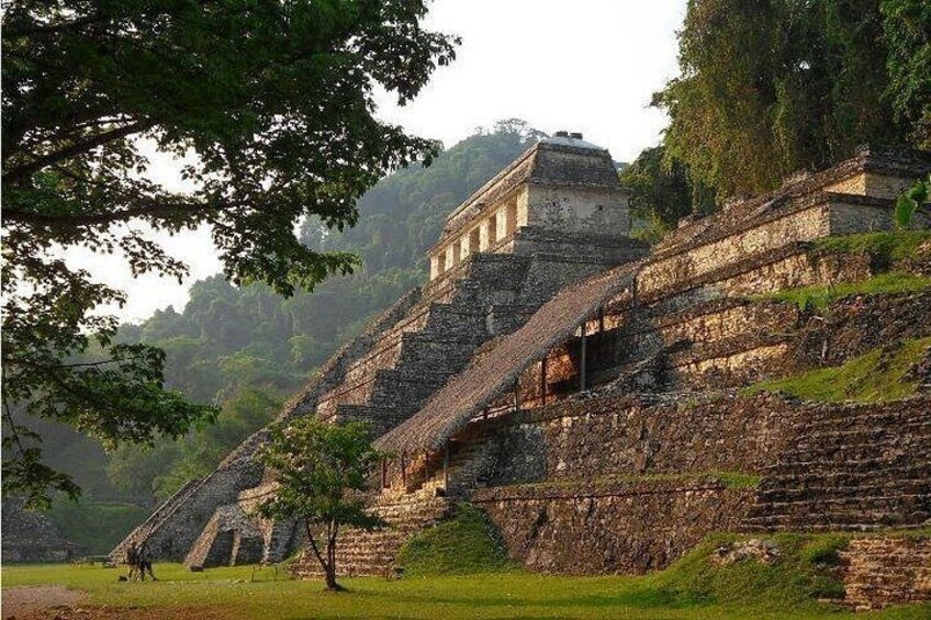 A large ancient pyramid with a temple on top, surrounded by lush greenery. 2