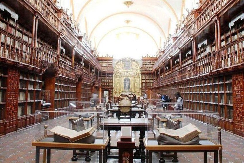 Una biblioteca imponente con estanterías de madera decoradas y un altar central ornamentado. 2