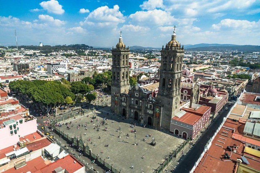 Una catedral histórica con dos torres, una plaza y edificios urbanos circundantes. 4