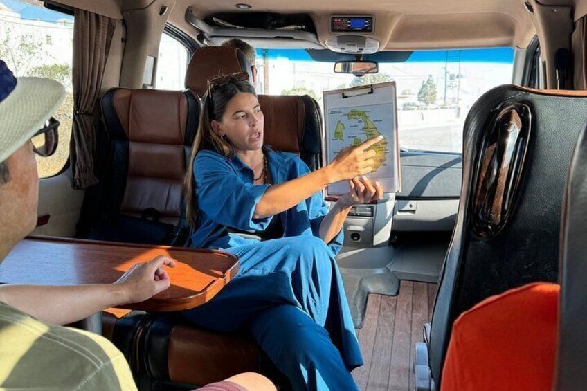 A person holding a map in a vehicle with leather seats and a digital device on the dashboard. 2