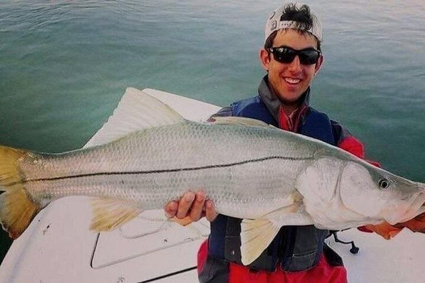 A person holding a large fish on a boat. 5